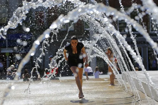 Tatiana Toth runs through a fountain in Nottingham, Britain June 30, 2015. (Photo by Darren Staples/Reuters)