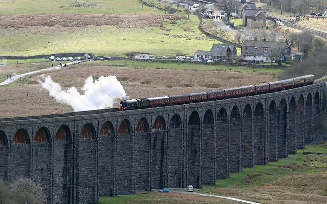 The “Flying Scotsman” crosses the Ribblehead viaduct in North Yorkshire, England as the Settle-Carlisle railway line reopens after floods on March 30, 2017. (Photo by Owen Humphreys/PA Wire)