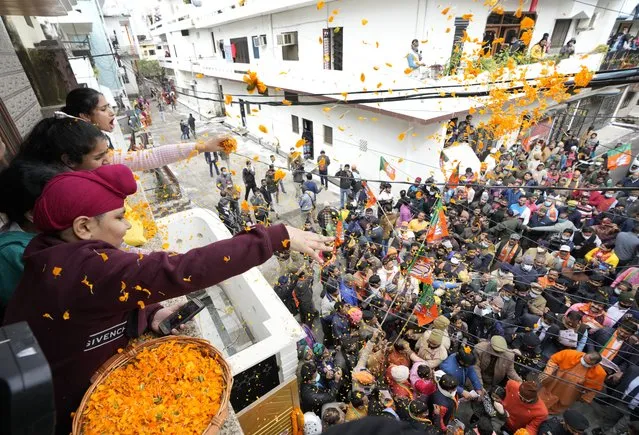 Women and children throw flower petals as Uttar Pradesh Chief Minister Yogi Adityanath meets residents of a Sikh locality during a campaign for the upcoming state assembly elections in Gorakhpur, India, Saturday, February 5, 2022. Weeks-long ballots will take place in Uttar Pradesh, India’s largest state with a population of more than 200 million, as well as states such as Punjab, Uttarakhand, Goa and Manipur. Coronavirus is still spreading rapidly through India, prompting anxiety as elections will attract millions to polling booths. (Photo by Rajesh Kumar Singh/AP Photo)
