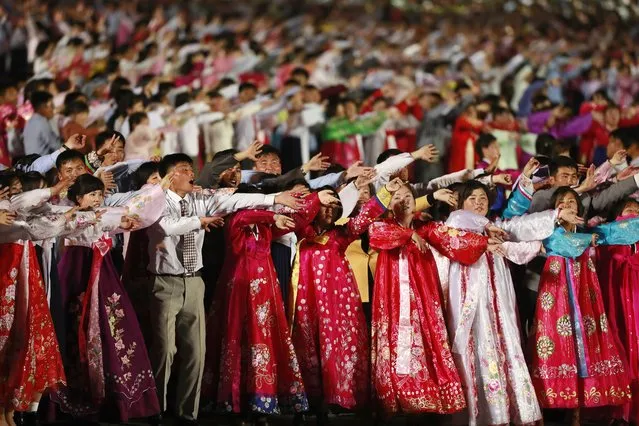 North Korean men and women perform a mass dance during a parade for the “Day of the Sun” festival on Kim Il Sung Square in Pyongyang, North Korea, 15 April 2017. (Photo by How Hwee Young/EPA)