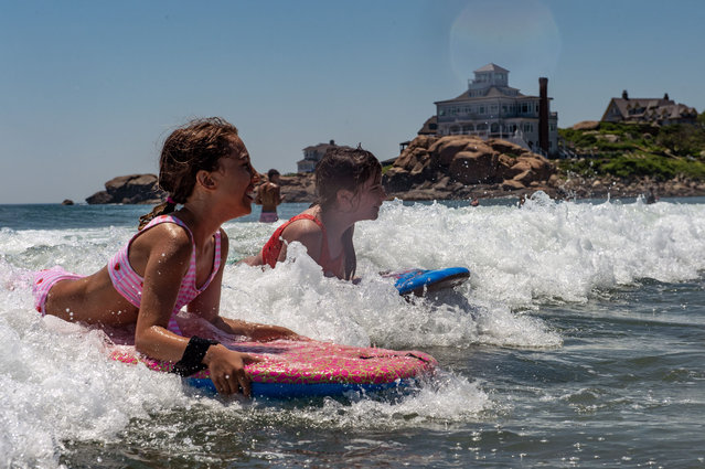 Children catch the waves on their boogie boards at Good Harbor Beach in Gloucester, Massachusetts, United States on June 25, 2024. New England temperatures reached into the high 80's(F) and low 90's(F) this week after a heatwave brought temperatures close to 100(F) last week. Heat domes causing heatwaves have been hitting the US over the past week with high alerts placed in the I-95 corridor on the East Coast. The National weather service has predicted above-normal temperatures for most the US for the month of July. (Photo by Joseph Prezioso/Anadolu via Getty Images)