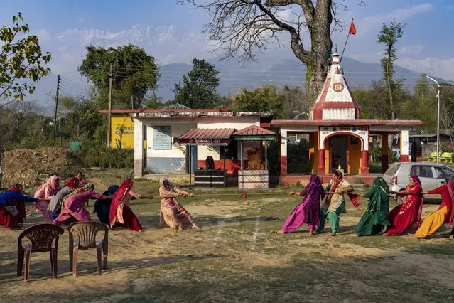 Village women compete in a tug-of-war in the compound of a Hindu temple at Hungloh village, south of Dharmsala, India, Monday, March 14, 2022. (Photo by Ashwini Bhatia/AP Photo)