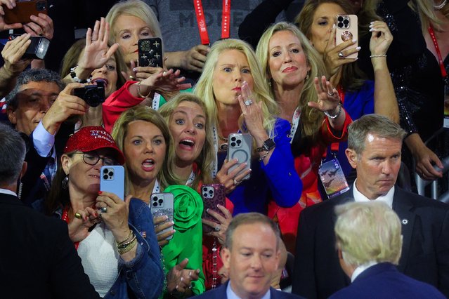 Women take photos and gesture to Donald Trump on Day 2 of the RNC in Milwaukee on July 16, 2024. (Photo by Brian Snyder/Reuters)