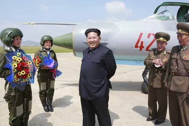 North Korean leader Kim Jong Un smiles as he attends a flight training session by female fighter pilots Jo Kum Hyang and Rim Sol in this undated photo released by North Korea's Korean Central News Agency (KCNA) on June 22, 2015. (Photo by Reuters/KCNA/Antara Foto)