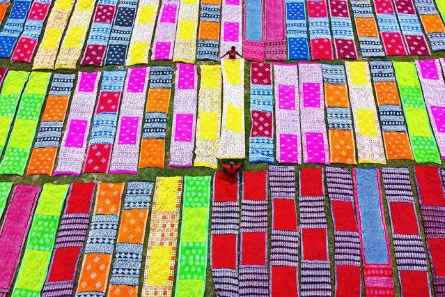 Colourful strips of fabric, which will be used to fashion sarees in Narayanganj in Bangladesh, make an eye-catching display as they are laid out to dry in the sun on March 29, 2022. (Photo by Joy Saha/Solent News)