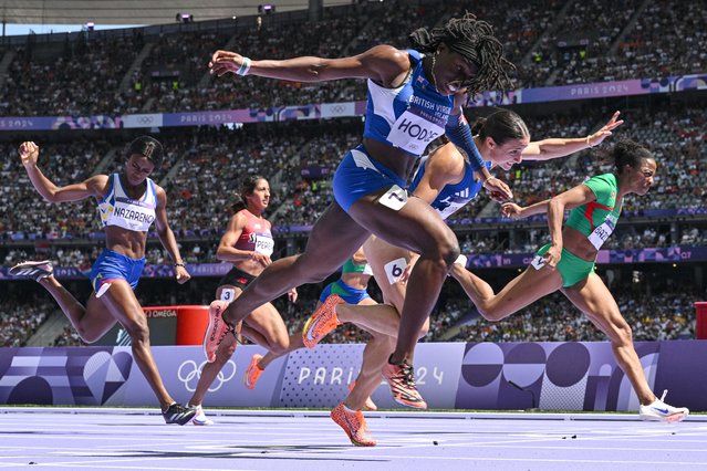 British Virgin Islands' Adaejah Hodge (front) crosses the finish line in the women's 200m repechage round of the athletics event at the Paris 2024 Olympic Games at Stade de France in Saint-Denis, north of Paris, on August 5, 2024. (Photo by Jewel Samad/AFP Photo)