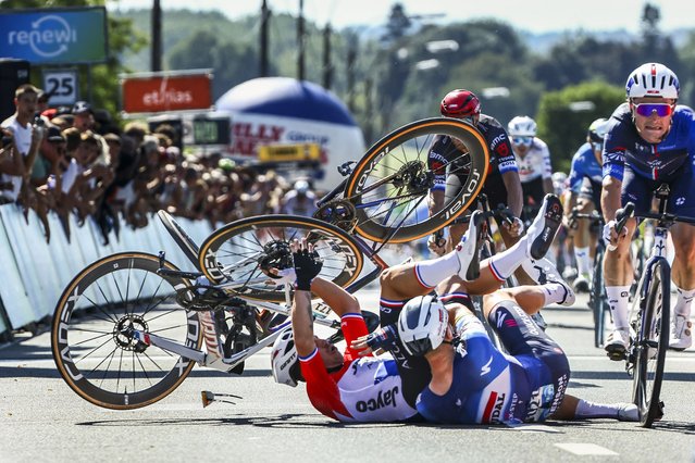 Team Jayco Alula's Dutch rider Dylan Groenewegen (L) and Soudal Quick-Step's Belgian rider Tim Merlier (2ndL) crash at the end of the first stage of the Renewi Tour multi-stage cycling race, from Riemst to Bilzen (163,6 km) on August 28, 2024. The five-day race takes place in Belgium and the Netherlands. (Photo by David Pintens/Belga via AFP Photo)