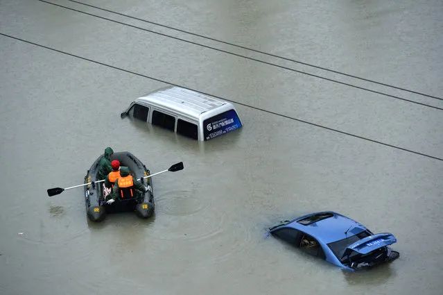A rescue boat approaches a submerged car on a flooded street after heavy rainfall in Guiyang city, Guizhou province, China on June 12, 2017. (Photo by Reuters/Stringer)