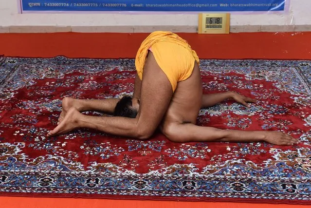 This photo taken on June 19, 2017 shows Indian yoga teacher Mahesh Yogiji attempting a world record for the longest yoga session in Ahmedabad, ahead of International Yoga Day on June 21. According to Guiness World Records, the longest yoga marathon undertaken by a man lasted 69 hours and was achieved by V Gunasekaran in Tamil Nadu in June 2016. (Photo by Sam Panthaky/AFP Photo)