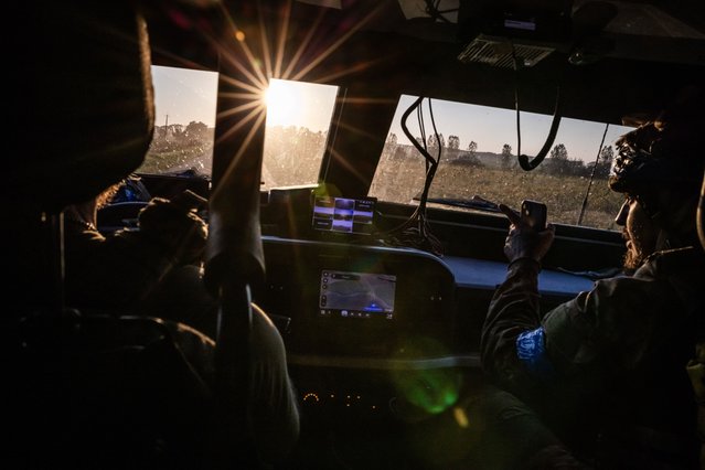 A Ukrainian soldier points out the window of an armored vehicle while traveling on Russian territory in the Kursk region on August 18, 2024. Ukrainian forces operating in the region destroyed a second key bridge, the commander of the Ukrainian air force said, as they attempt to push farther into Russia. (Photo by Ed Ram for The Washington Post)