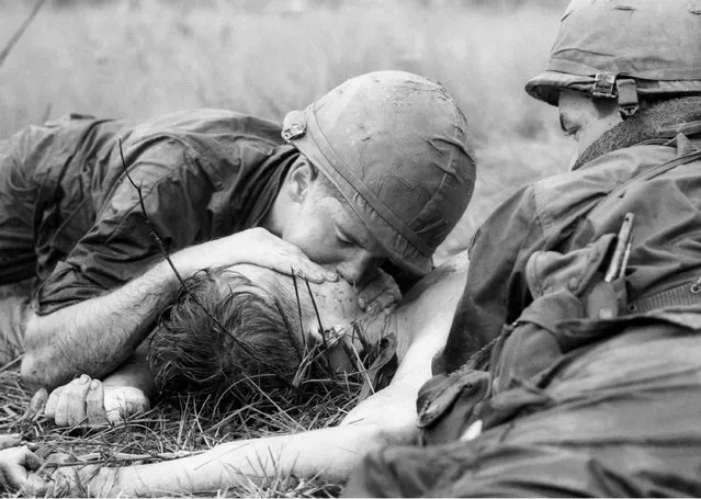 Medic James E. Callahan of Pittsfield, Mass., gives mouth-to-mouth resuscitation to a dying soldier in war zone D, about 50 miles northeast of Saigon, June 17, 1967. Thirty-one men of the 1st Infantry Division were reported killed in the guerrilla ambush, with more than 100 wounded.  (Photo by Henri Huet/AP Photo)