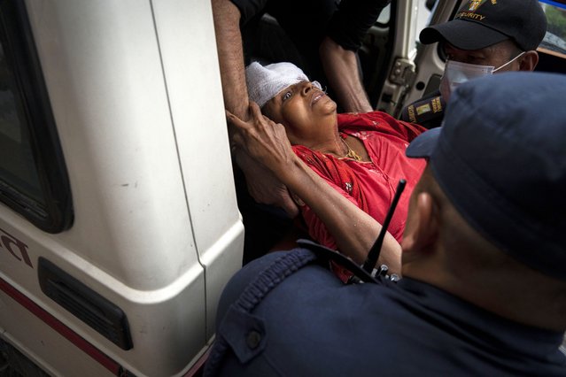 An injured woman is brought for treatment at a hospital, after a bus carrying Indian tourists fell into a river near Abukhaireni town about 75 miles west of the capital Kathmandu, Nepal, Friday, August 23, 2024. (Photo by Niranjan Shrestha/AP Photo)