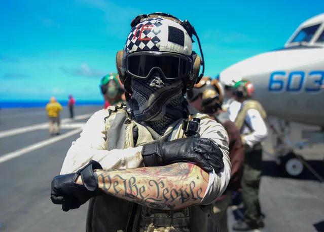 Aviation Electrician's Mate 2nd Class Lucas Mclean displays a tatto reading “We The People”, from the Preamble to the United States Constitution, aboard the U.S. Navy aircraft carrier USS Nimitz in the Pacific Ocean June 30, 2017. (Photo by Mass Communication Specialist 3rd Class Ian Kinkead/Reuters/U.S. Navy)