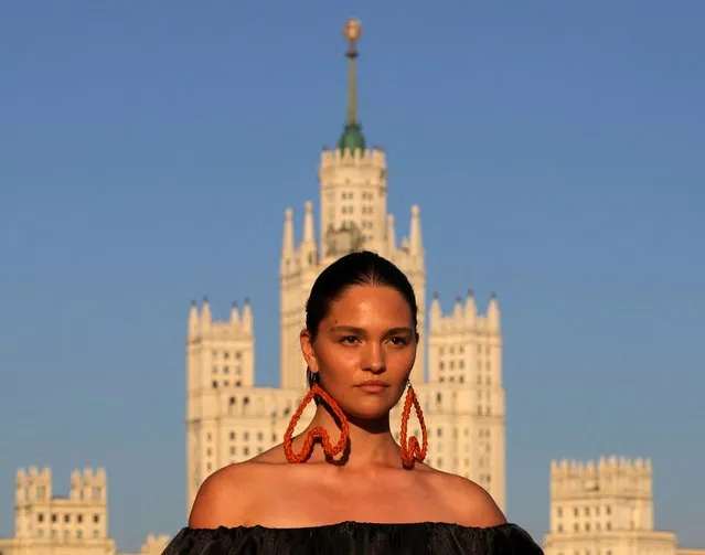 A model presents a creation by Russian design house ALENA AKHMADULLINA at the embankment of Moskva river, with a Soviet era skyscraper on Kotelnicheskaya Embankment seen in the background, in central Moscow, Russia, June 23, 2022. (Photo by Evgenia Novozhenina/Reuters)