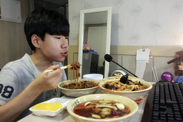 In this Monday, August 17, 2015 photo, Kim Sung-jin, 14, broadcasts himself eating delivery Chinese food in his room at home in Bucheon, south of Seoul, South Korea. (Photo by Julie Yoon/AP Photo)