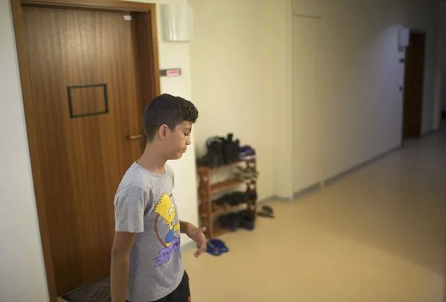 Patriz, a migrant child from the Balkans, walks across the corridor of the  “Sharehaus Refugio” community in Berlin, where Germans and migrants live together, Germany August 19, 2015. (Photo by Axel Schmidt/Reuters)