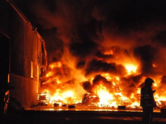 A large quantity of tyres alight at a recycling site in Renfrew, outside Glasgow, on Jule 11, 2014. (Photo by Scottish Fire and Rescue Service/PA Wire)