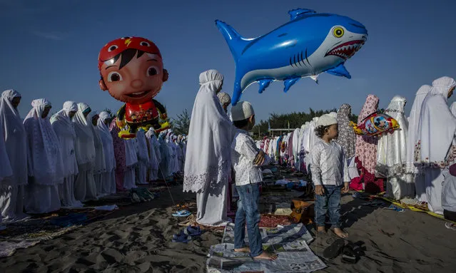 Indonesian muslims perform Eid Al-Fitr prayer on “sea of sands” at Parangkusumo beach on July 6, 2016 in Yogyakarta, Indonesia. Eid Al-Fitr marks the end of Ramadan, during which Muslims in countries around the world spend time with family, offer gifts and often give to charity. (Photo by Ulet Ifansasti/Getty Images)