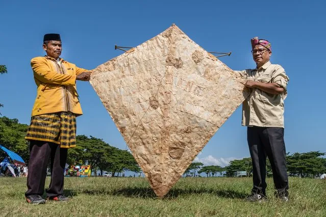 The owner of an ancient kite shows his kite before it is flown in in Raha, Indonesia on July 23, 2022. The Kaghati Kolope or ancient kite is the oldest kite in the world, aged 4 thousand years, based on historical discoveries found in one of the caves on the island of Muna, Southeast Sulawesi. All the constituent parts of this ancient kite are composed of materials derived from nature where the main ingredient is kolope leaves. (Photo by Andry Denisah/SOPA Images/Rex Features/Shutterstock)