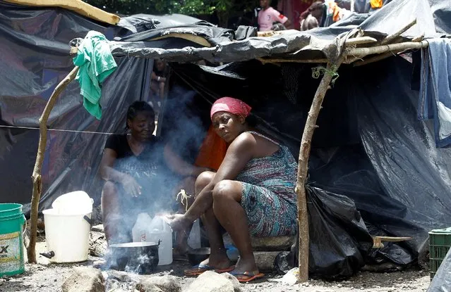 Two African migrants stranded in Costa Rica cook food in their tent at a makeshift camp at the border between Costa Rica and Nicaragua, in Penas Blancas, Costa Rica, July 14, 2016. (Photo by Juan Carlos Ulate/Reuters)
