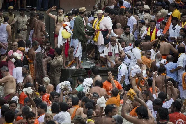 Hindu devotees take a bath in the Godavari River during Kumbh Mela, or Pitcher Festival, in Nasik, India, Saturday, August 29, 2015. (Photo by Bernat Armangue/AP Photo)