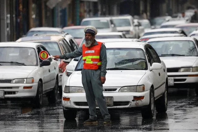 A traffic police officer stands on a street in Kabul, Afghanistan on August 2, 2022. (Photo by Ali Khara/Reuters)