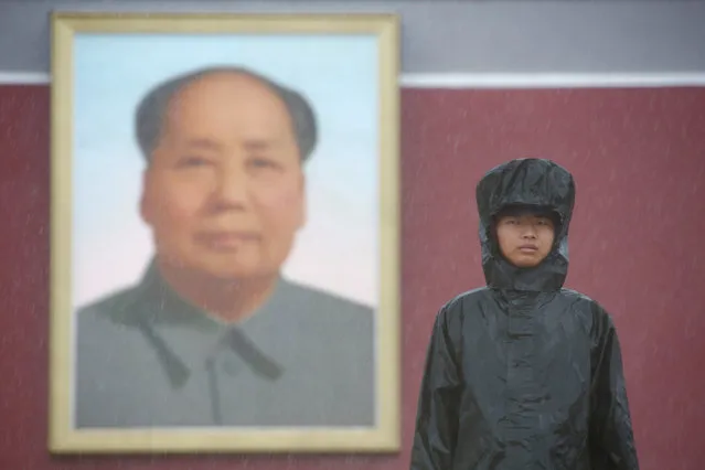 A paramilitary police officer stands in front of a giant portrait of Chinese late Chairman Mao Zedong on a day of heavy rain in Beijing, China, July 20, 2016. (Photo by Thomas Peter/Reuters)