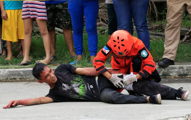 A rescuer bandages the leg of a mock victim during an earthquake drill as part of the joint capability demonstration of the Philippine Armed Forces' Reserve Command along with other government agencies in observance of national disaster consciousness month in Taguig city, metro Manila, Philippines July 30, 2016. (Photo by Romeo Ranoco/Reuters)