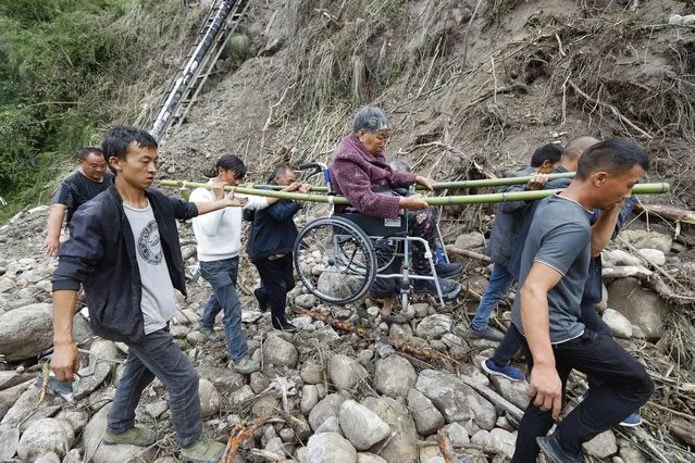 In this photo released by Xinhua News Agency, people carry out an injured person evacuated in the aftermath of an earthquake from Mozigou village near Moxi Town of Luding County, southwest China's Sichuan Province, September 8, 2022. Heavy rains are complicating earthquake recovery efforts in southwestern China, where the death toll from Monday's disaster has risen. (Photo by Shen Bohan/Xinhua via AP Photo)