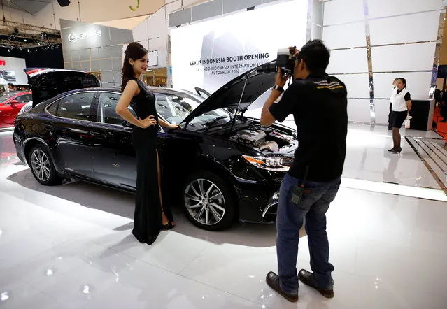 A model poses for a photographer beside a Lexus at the Indonesia International Auto Show in Tangerang, west of Jakarta, Indonesia August 11, 2016. (Photo by Darren Whiteside/Reuters)