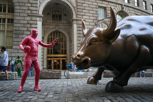 An artist name Theodore Tsinias who wrapped himself next to the Charging Bull to show his attention about world's behave amid Covid-19 pandemic in Lower Manhattan, New York City, United States on May 25, 2020. U.S Covid-19 victims have reached nearly to 100K as of today. (Photo by Tayfun Coskun/Anadolu Agency via Getty Images)