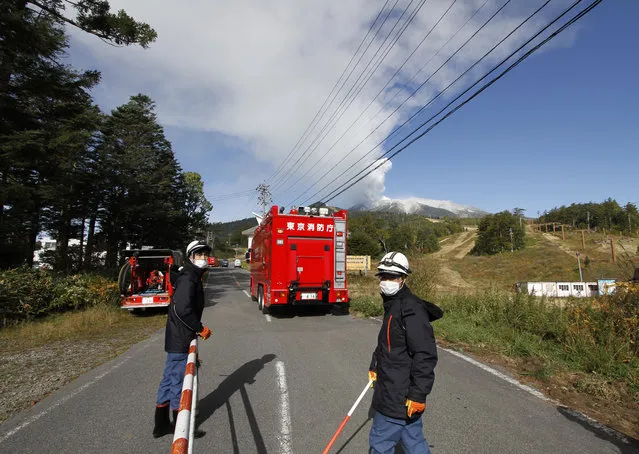 Otaki Village firefighters control access to a road leading to Mount Ontake, background right, as it continues to erupt Sunday, September 28, 2014, in Otaki Village, Nagano prefecture, Japan. (Photo by Koji Ueda/AP Photo)