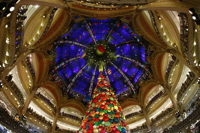 A giant Christmas Tree stands in the center dome as Singer Beth Ditto performs to inaugurate the the Christmas season at the Galeries Lafayette department store in Paris, France, Wednesday, November 8, 2017. (Photo by Francois Mori/AP Photo)