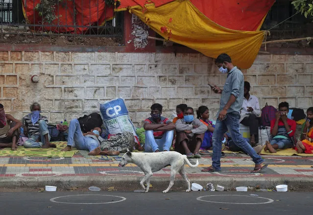 Migrant workers from other states rest on a pavement as they wait for trains to their home states in Hyderabad, India, Tuesday, June 9, 2020. India is reopening its restaurants, shopping malls and religious places in most of its states after a more than 2-month-old lockdown even as the country continues to witness a worrying rise in new coronavirus infections. (Photo by Mahesh Kumar A./AP Photo)