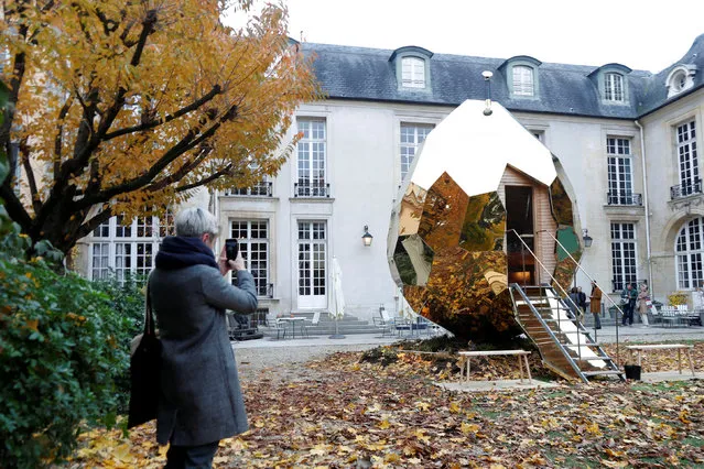 A visitor takes a picture of Swedish sauna Solar Egg temporarily exhibited at the Swedish institut in Paris, France, November 15, 2017. The Solar Egg, a traditional sauna room created by artists Mats Bigert and Lars Bergstrom, was originally constructed in Kiruna in the Swedish Lapland, as a meeting place for residents who were displaced by mining. (Photo by Charles Platiau/Reuters)