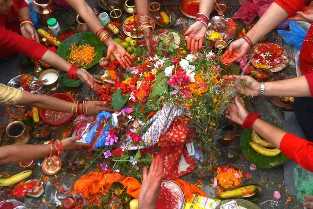 Hindu devotees offer prayers on the banks of the Bagmati River on the occasion of Rishi Panchami at the end of the three-day long Teej Festival, in which Hindu women fast during the day and pray for the long lives for their husbands, in Kathmandu on September 1, 2022. (Photo by Prakash Mathema/AFP Photo)