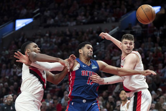 Portland Trail Blazers forward Jabari Walker, left, and Donovan Clingan, right, defend as Detroit Pistons forward Tobias Harris (12) tries to go for the ball during the second half of an NBA basketball game Sunday, March 9, 2025, in Portland, Ore. (Photo by Jenny Kane/AP Photo)