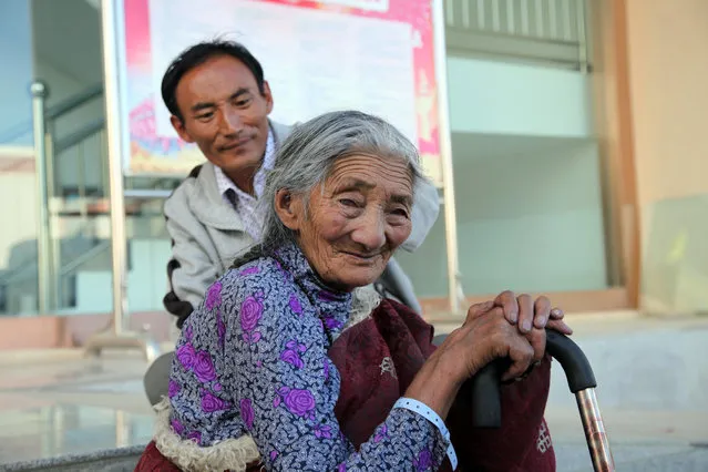 In this Friday, September 18, 2015 photo, a 100-year-old Tibetan woman rests with her grandson outside the Tibetan Medicine Hospital in Lhasa, capital of the Tibet Autonomous Region in China. (Photo by Aritz Parra/AP Photo)