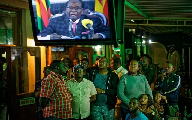 Zimbabweans watch a televised address to the nation by President Robert Mugabe at a bar in downtown Harare, Zimbabwe Sunday, November 19, 2017. Zimbabwe's President Robert Mugabe has baffled the country by ending his address on national television without announcing his resignation. (Photo by Ben Curtis/AP Photo)