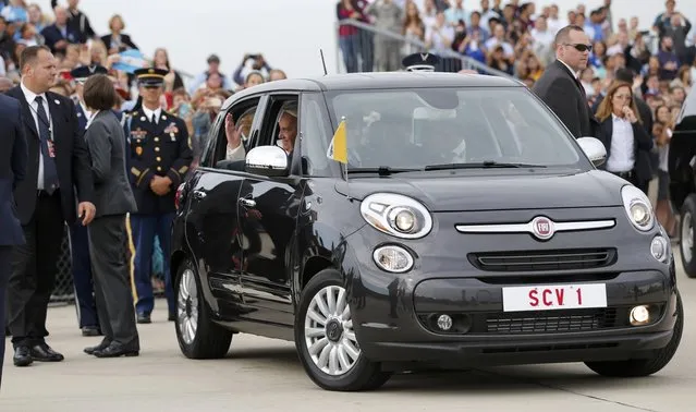 Pope Francis waves as he is driven away in a Fiat 500 model after arriving in the United States at Joint Base Andrews outside Washington September 22, 2015. (Photo by Jonathan Ernst/Reuters)