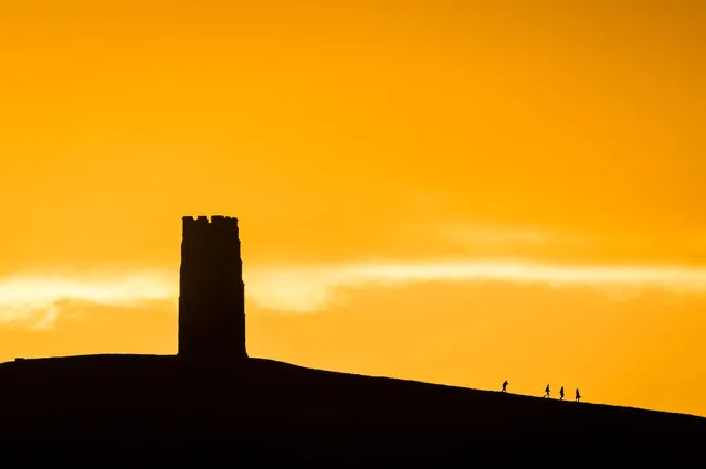 People trek from St Michael’s Tower after watching the sun rise over Glastonbury Tor, Somerset, England on November 26, 2017 as forecasters issued a yellow ‘be aware’ weather warning for western Britain. (Photo by Ben Birchall/PA Images via Getty Images)