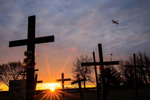 A plane flies over makeshift crosses near the Ronald Reagan Washington National Airport on Sunday, February 2, 2025. The memorial was set up to pay tribute to the 67 people who were killed last month when a passenger plane approaching the airport collided with a US Army helicopter in midair, sending both aircraft into the Potomac River below. It was the deadliest aviation disaster in the United States since November 2001. (Photo by Eduardo Munoz/Reuters)