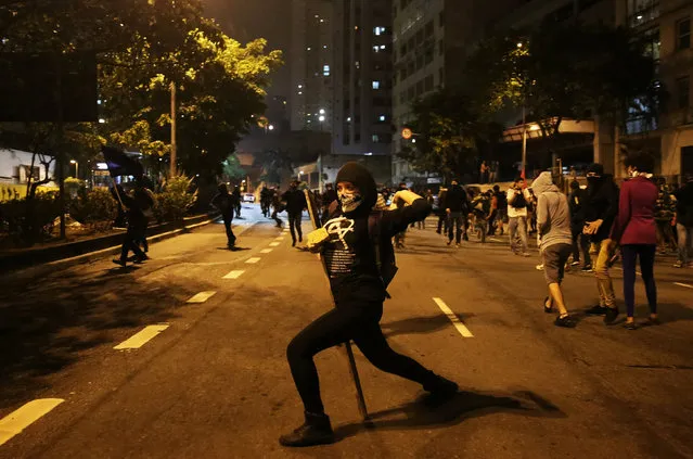 A demonstrator throws stones at riot police (not pictured) during a protest against Brazil's new President Michel Temer after Brazil's Senate removed former president Dilma Rousseff in Sao Paulo, Brazil, September1, 2016. (Photo by Nacho Doce/Reuters)