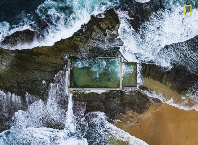 1st Place in Aerials: In Sydney, Australia, the Pacific Ocean at high tide breaks over a natural rock pool enlarged in the 1930s. Avoiding the crowds at the city's many beaches, a local swims laps. (Photo by Todd Kennedy/National Geographic Nature Photographer of the Year contest 2017)