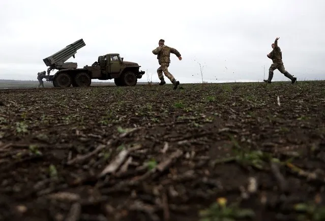 Ukrainian servicemen rush to change their BM-21 Grad's position after firing towards Russian positions on the front line near Bakhmut, eastern Ukraine, on November 27, 2022, amid the Russian invasion of Ukraine. (Photo by Anatolii Stepanov/AFP Photo)