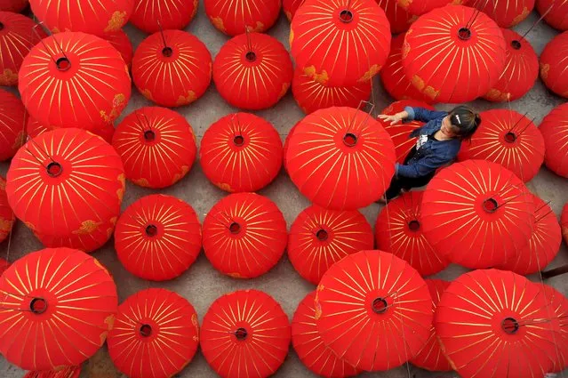 A worker shines red lanterns with the word “Chinese Dream” painted on at a lantern industrial park, September 19, 2015, in Yuncheng, China. Hundreds of workers made red lanterns in west China's Shanxi Province to welcome the upcoming “National Day” which will fall on October 1st. (Photo by ChinaFotoPress/Getty Images)