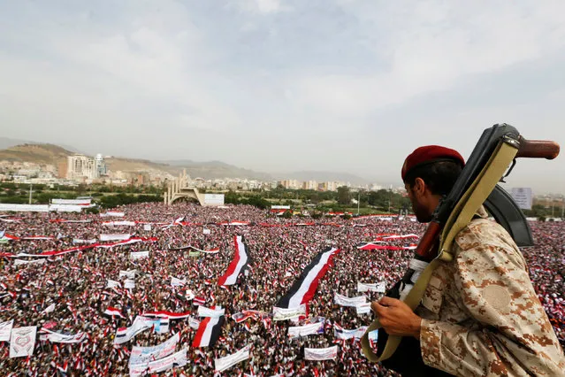 A soldier looks at people rallying to show support to a political council formed by the Houthi movement and the General People's Congress party to unilaterally rule Yemen by both groups, in the capital Sanaa August 20, 2016. (Photo by Khaled Abdullah/Reuters)