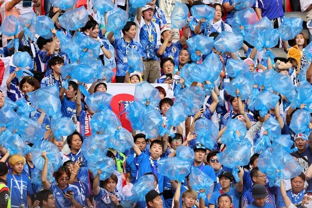 Japan fans hold aloft blue plastic waste sacks prior to collecting their refuse following the final whistle of the FIFA World Cup Qatar 2022 Group E match between Japan and Costa Rica at Ahmad Bin Ali Stadium on November 27, 2022 in Doha, Qatar. (Photo by Youssef Loulidi/Fantasista/Getty Images)