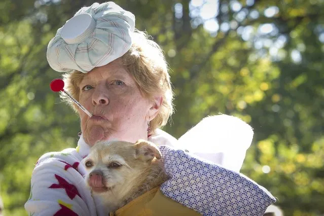 A woman poses for a photo with her dog during the 24th Annual Tompkins Square Halloween Dog Parade in New York October 25, 2014. (Photo by Carlo Allegri/Reuters)