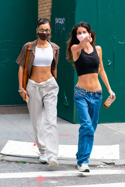 American model Bella Hadid is pictured out with a girlfriend in SoHo in New York City on August 12, 2020. The 23 year old supermodel wore a face mask, cropped tank top, striped shirt, grey trousers, and matching trainers. (Photo by TheImageDirect.com)